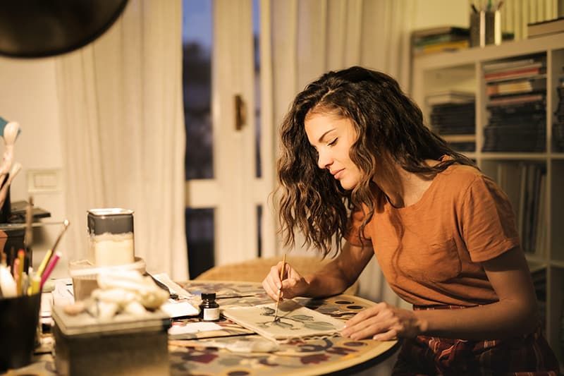 Frau malt im Atelier auf Papier