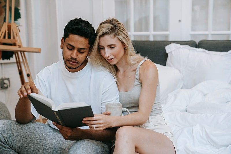 Ein Paar liest zu Hause gemeinsam ein Buch