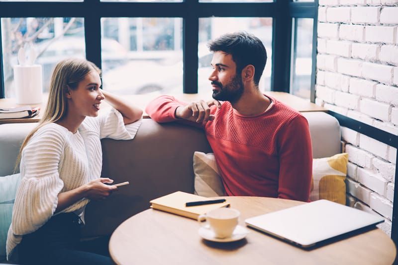 Mann und Frau unterhalten sich im Café bei einem Date