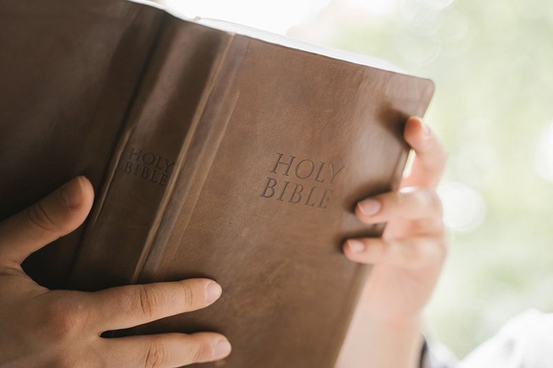 Person, die die Bibel hält und sie liest