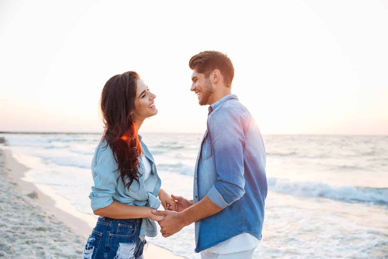 Glückliches Paar hält Händchen am Strand