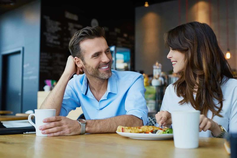 Ein Mann und eine Frau sitzen an einem Tisch und unterhalten sich beim Frühstück