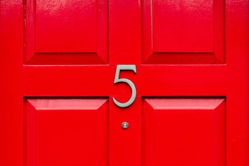 Nummer 5 auf einer roten Holztür