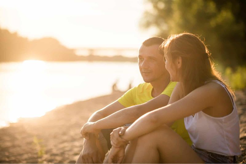 Ein Mann und eine Frau sitzen am Strand und unterhalten sich