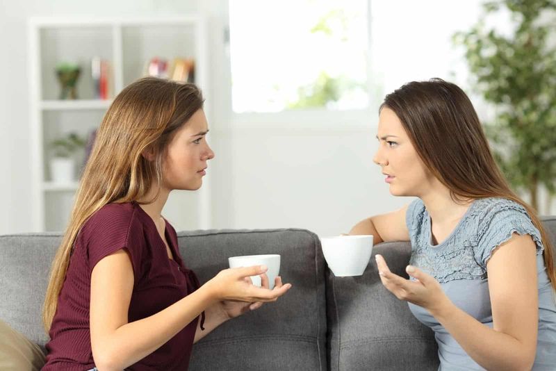 Zwei ernsthafte Freunde unterhalten sich bei einer Tasse Kaffee im Wohnzimmer