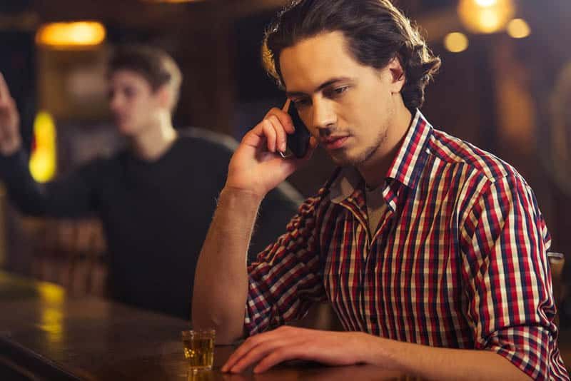 Mann telefoniert in der Bar