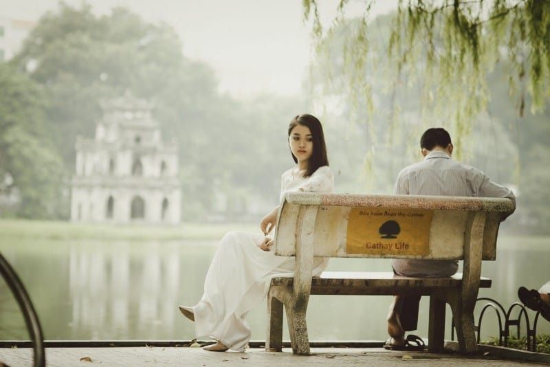 Frau und Mann sitzen auf einer Bank am Wasser