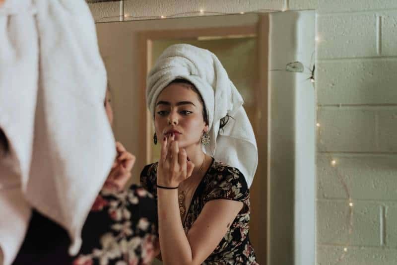 Frau schminkt sich vor dem Spiegel