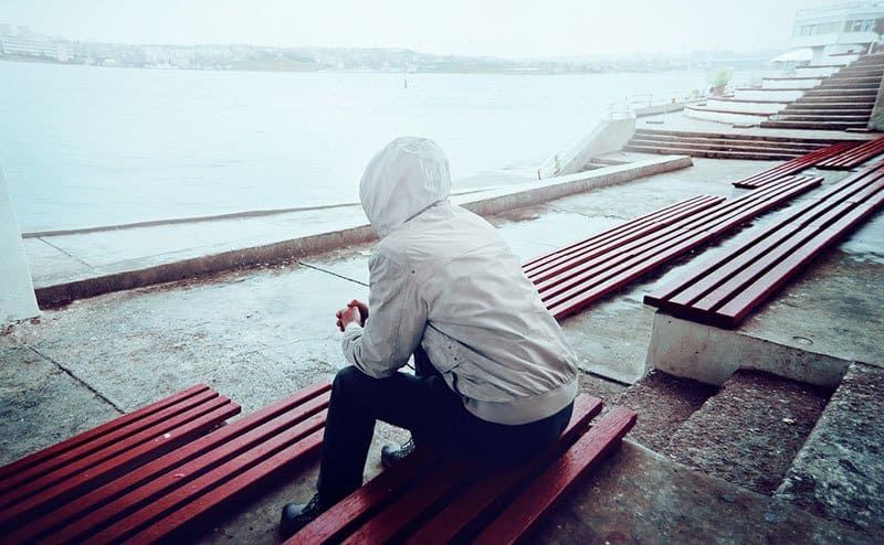 Trauriger Mann, der allein im Freien sitzt