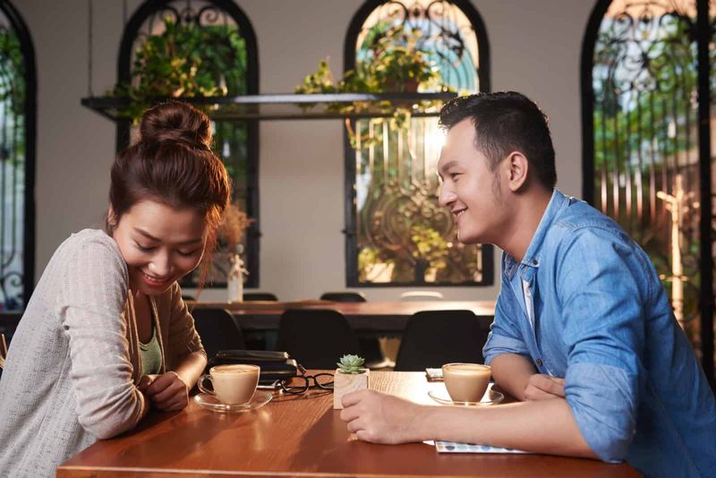 Seitenansichtporträt eines liebenden asiatischen Paares, das sich im Café zum Date trifft
