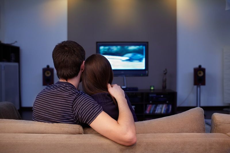 Ein Mann und eine Frau umarmten sich vor dem Fernseher