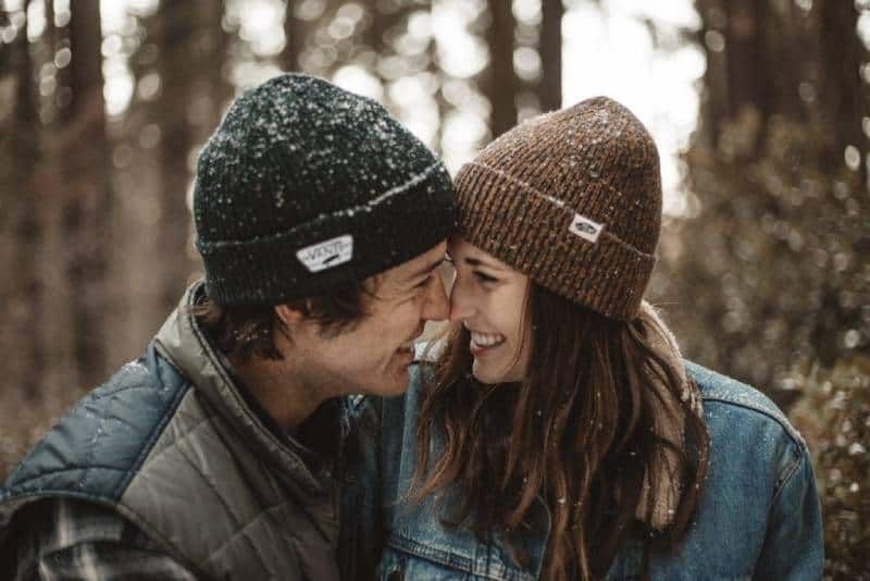 Lächelndes Paar, das sich im Winter anschaut