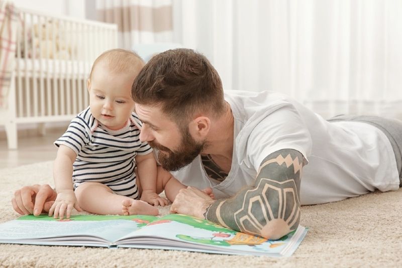 Mann mit Bart, der zu Hause mit Baby spielt