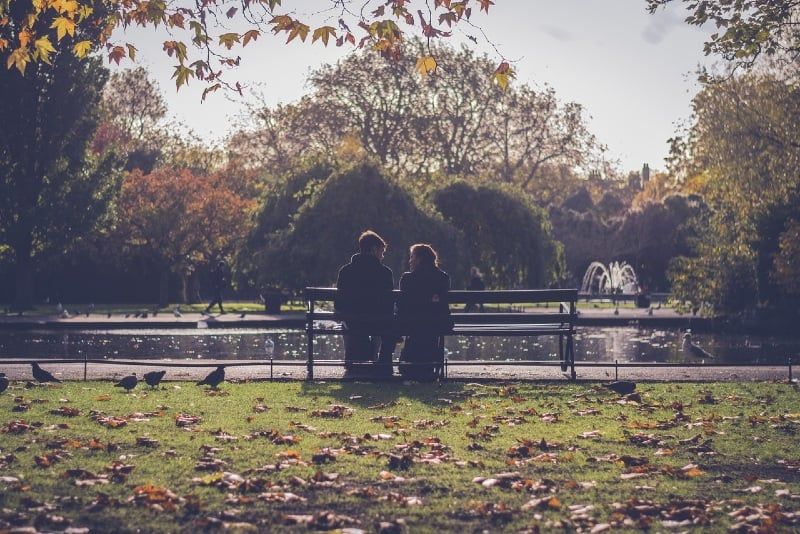 Mann und Frau sitzen auf einer Bank in der Nähe des Flusses