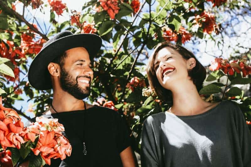 Lächelndes Paar umgeben von Blumen