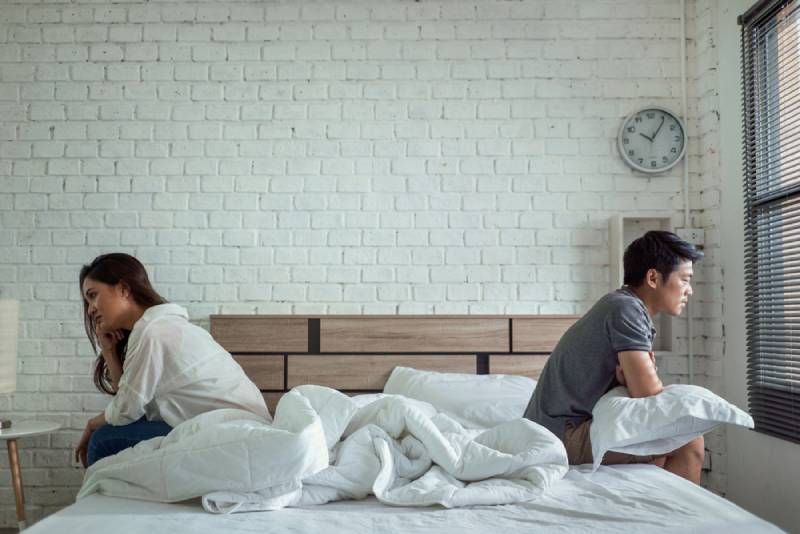 Paare streiten sich im Bett und streiten sich darum, nicht miteinander zu reden