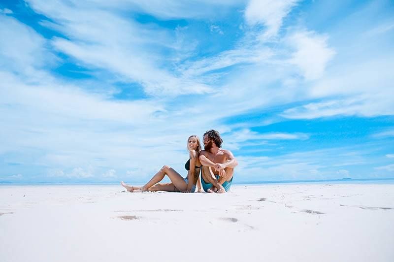 Mann und Frau sitzen tagsüber am Strand