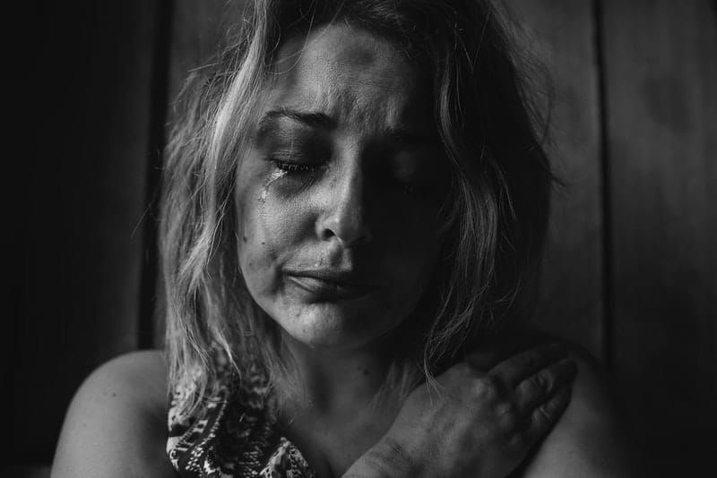 misshandelte Frau, die in grauem Farbschema weint