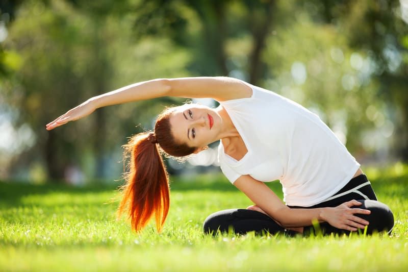 Glückliche Frau, die Yoga-Übungen macht