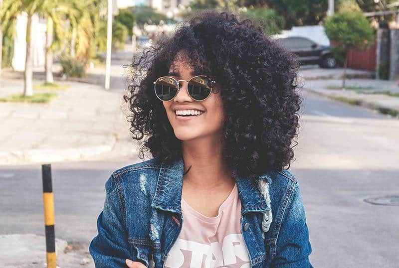 ein Porträt einer lächelnden schwarzen Frau mit Sonnenbrille