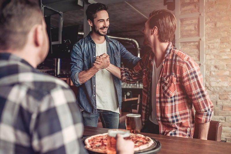 glückliche Männer treffen sich in der Pizzeria