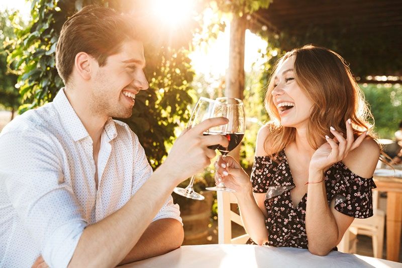 lächelndes Paar, das Wein trinkt