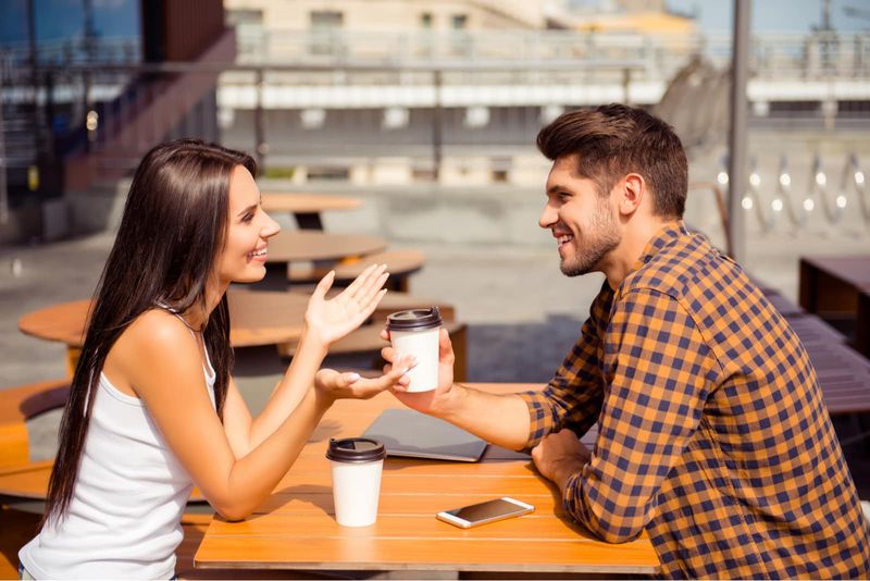 Ein Liebespaar, das auf der Terrasse eines Cafés Kaffee trinkt und sich unterhält