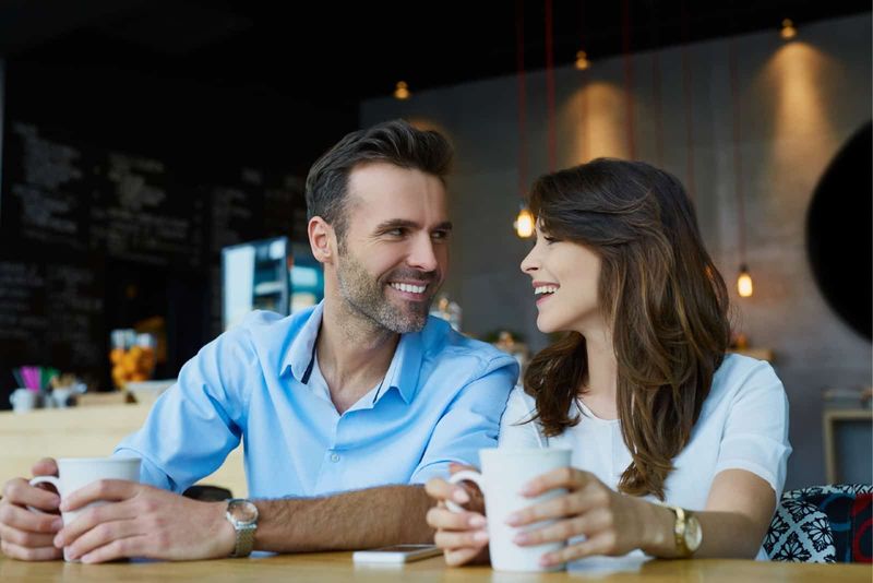 Mann und Frau unterhalten sich beim Kaffeetrinken im Café