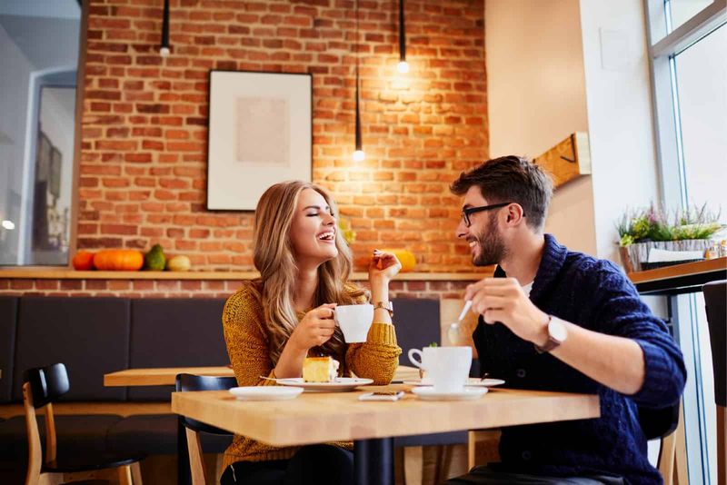 Mann und Frau trinken Kaffee, während sie im Café sitzen