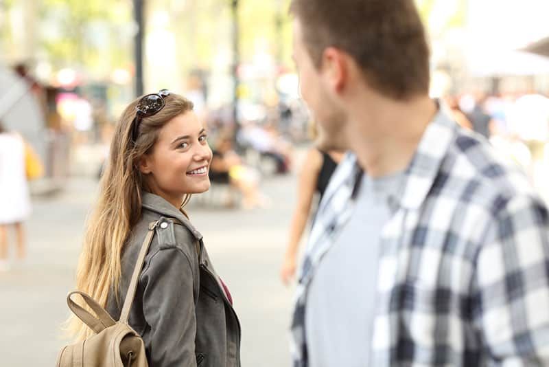 Frau flirtet mit Mann auf der Straße