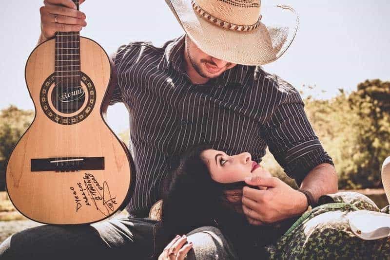 Mann hält eine Gitarre und schaut Frau an