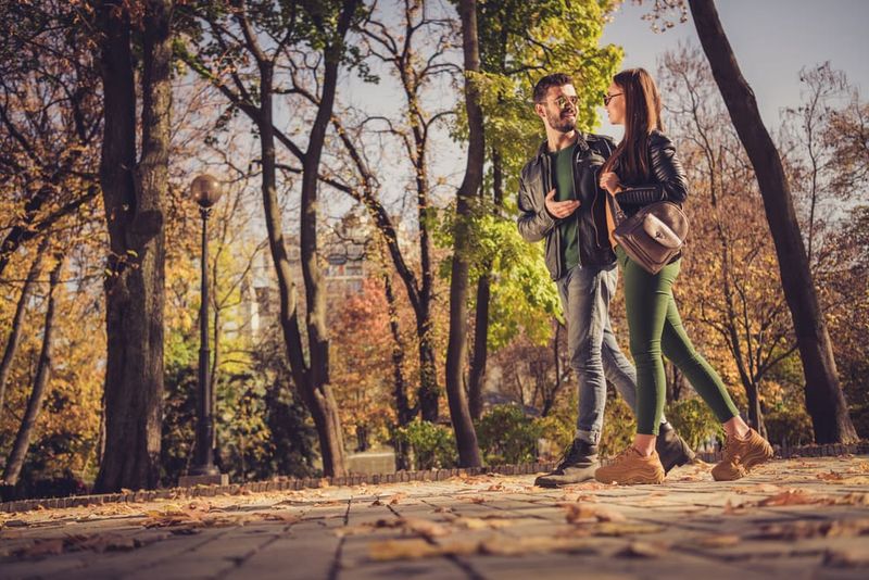 Ein attraktives Paar geht im Park spazieren und unterhält sich
