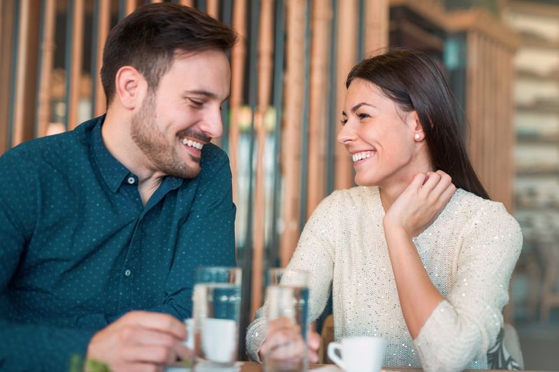 Ein gutaussehender Mann und eine Brünette flirten in einem Café