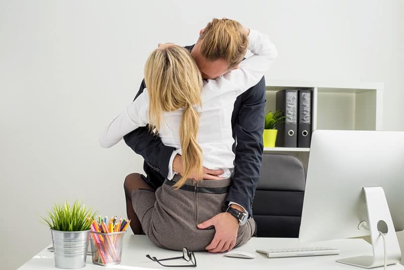 Paar küsst und berührt sich im Büro