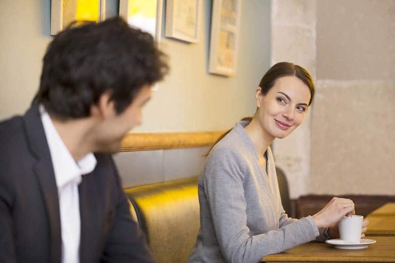 Nette Frau flirtet mit einem Mann in einer Bar oder einem Restaurant