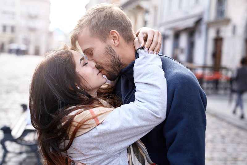 Ein romantisches Paar, das sich auf der Straße umarmt und küsst