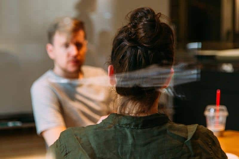 Foto mit flachem Fokus von Mann und Frau, die sich im Café unterhalten