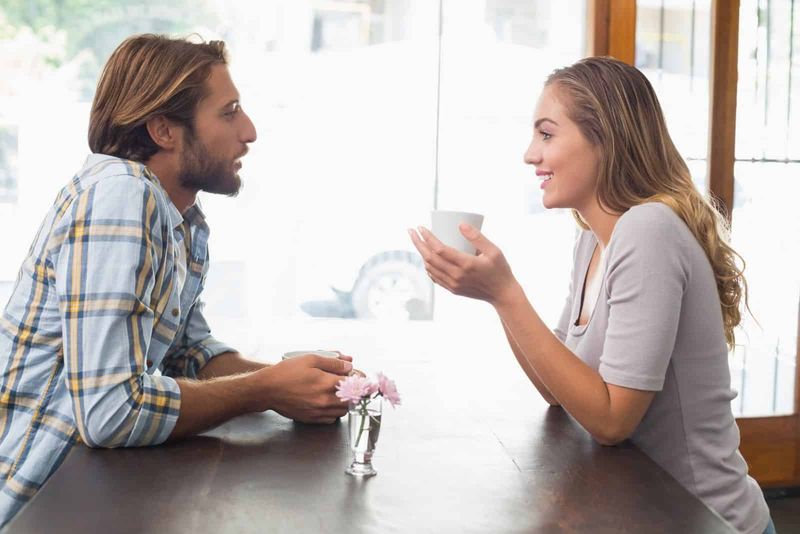 Lächelnder Mann und Frau sitzen und unterhalten sich beim Kaffee
