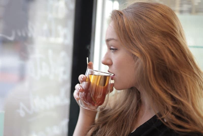 Nachdenken über eine Frau, die in einem Café heißen Tee trinkt