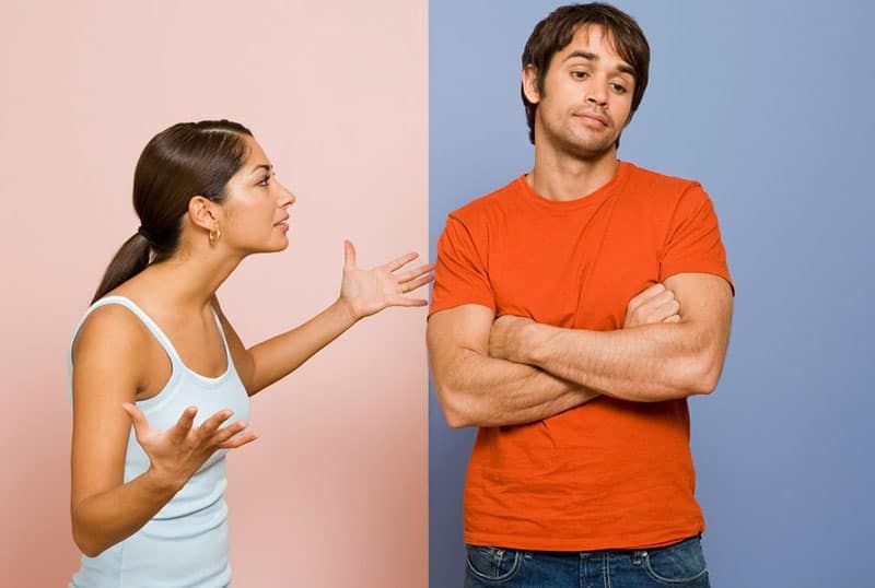 streitender Mann und Frau vor rosa und blauem Wandhintergrund