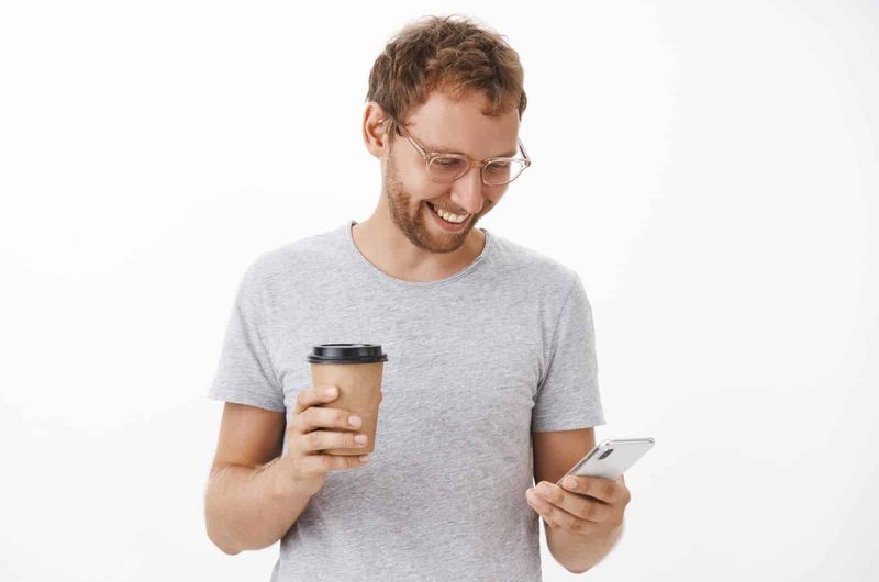 Mann, der gerne Guten-Morgen-Texte lächelt und SMS schreibt