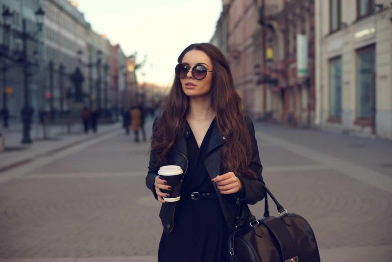 Eine Frau mit langen braunen Haaren geht die Straße entlang