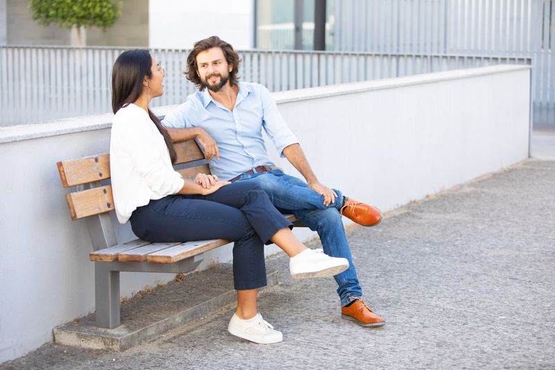 Paar sitzt auf Bank und redet