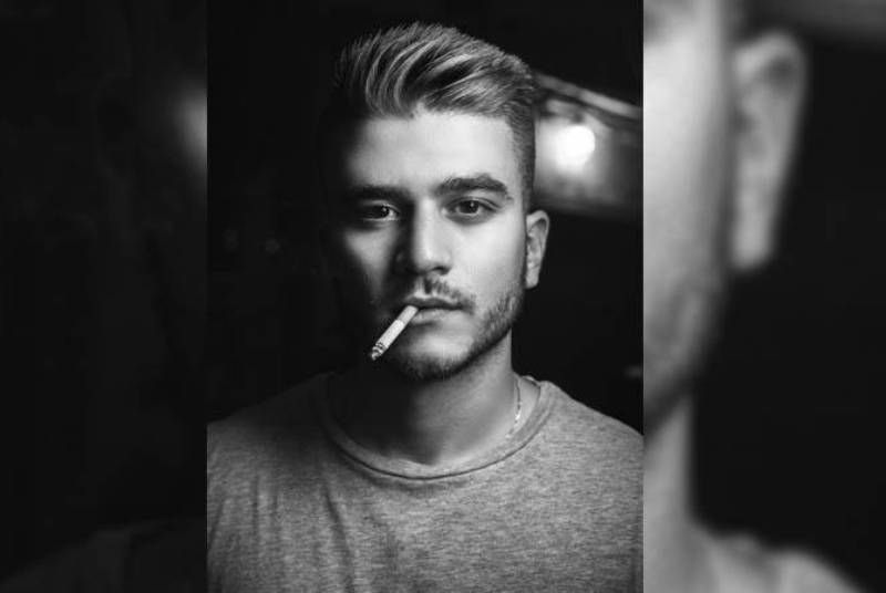 Schwarz-Weiß-Foto eines Mannes, der eine Zigarette raucht