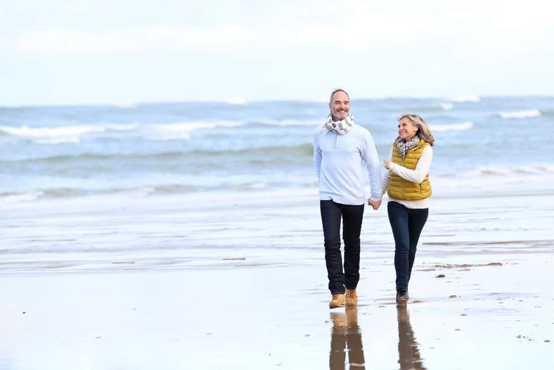 Älteres Paar läuft im Winter am Strand