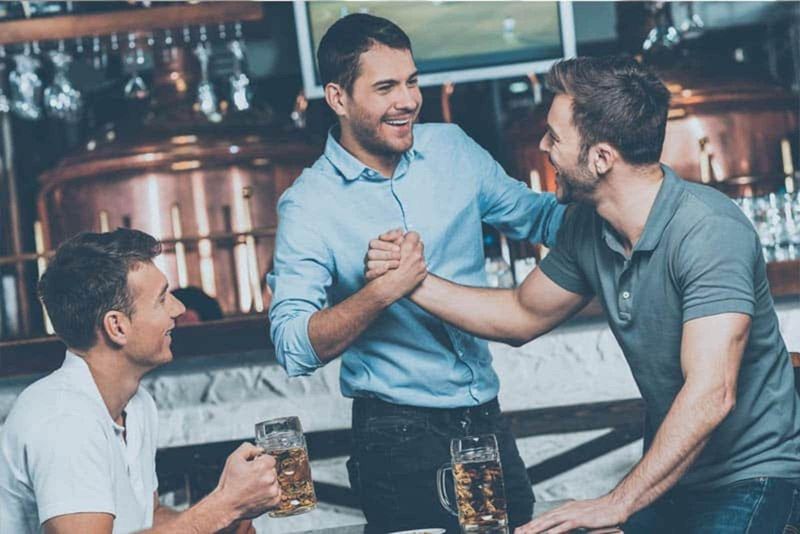 Mann mit seinem Freund in der Bar, der Bier trinkt