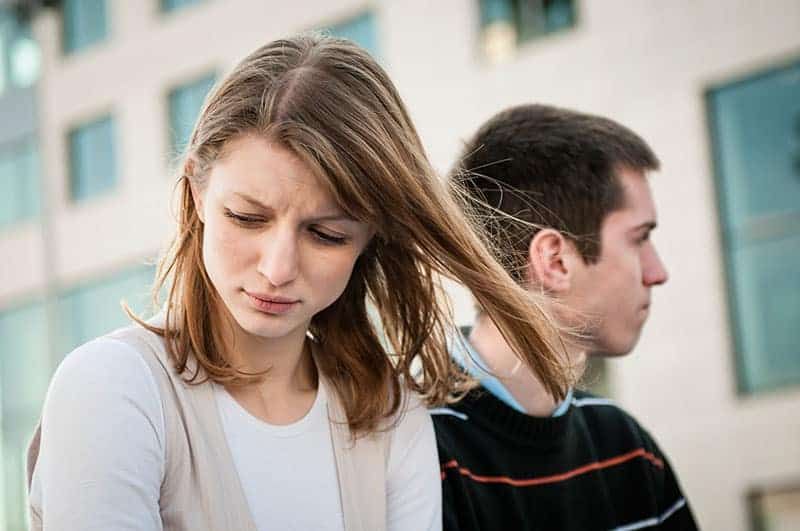 Porträt einer jungen Frau und eines jungen Mannes draußen auf der Straße, die Beziehungsprobleme haben