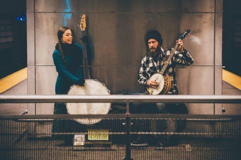 Mann und Frau spielen Streichinstrument im Bahnhof