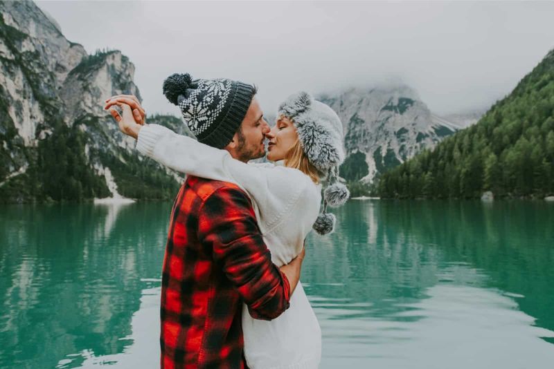 Mann und Frau wollen sich küssen, während sie am See stehen