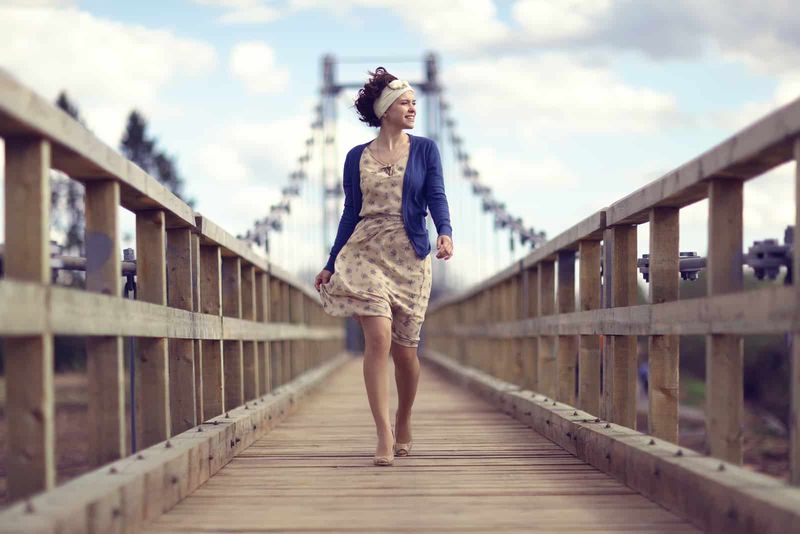 Eine schöne Frau in einem Kleid setzt die Brücke